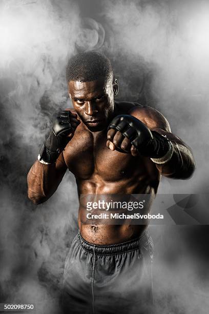 mma fighter on a smokey  background - mma fighters stock pictures, royalty-free photos & images