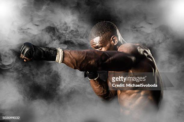mma fighter on a smokey  background - mixed martial arts stockfoto's en -beelden