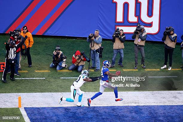 Rueben Randle of the New York Giants scores a 27 yard touchdown in the first quarter against Roman Harper of the Carolina Panthers during their game...