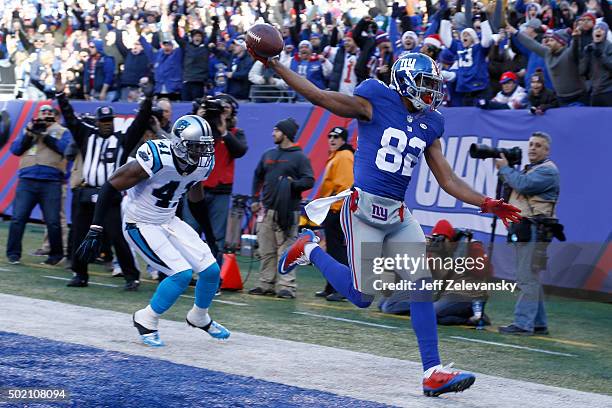 Rueben Randle of the New York Giants scores a 27 yard touchdown in the first quarter against Roman Harper of the Carolina Panthers during their game...