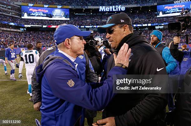 Head coach Ron Rivera of the Carolina Panthers talks with head coach Tom Coughlin of the New York Giants after their game at MetLife Stadium on...