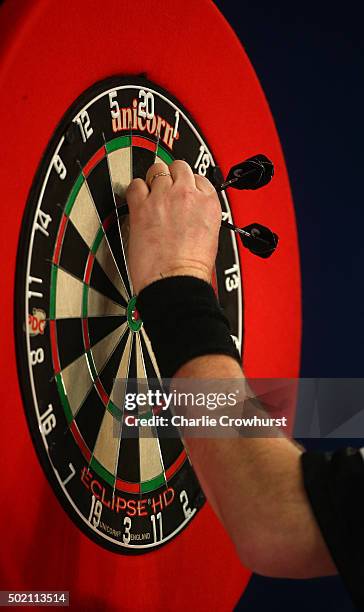 Raymond van Barneveld of Holland collects his darts out of the board during the 2016 William Hill PDC World Darts Championships on Day Four at...