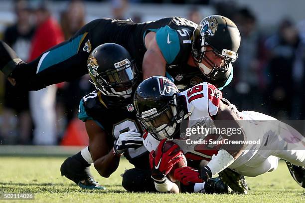 Justin Hardy of the Atlanta Falcons is tackled by Aaron Colvin and Paul Posluszny of the Jacksonville Jaguars during the game at at EverBank Field on...