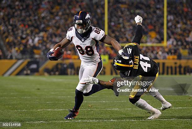 Demaryius Thomas of the Denver Broncos stiff arms Antwon Blake of the Pittsburgh Steelers as he runs the ball in for a second quarter touchdown doing...