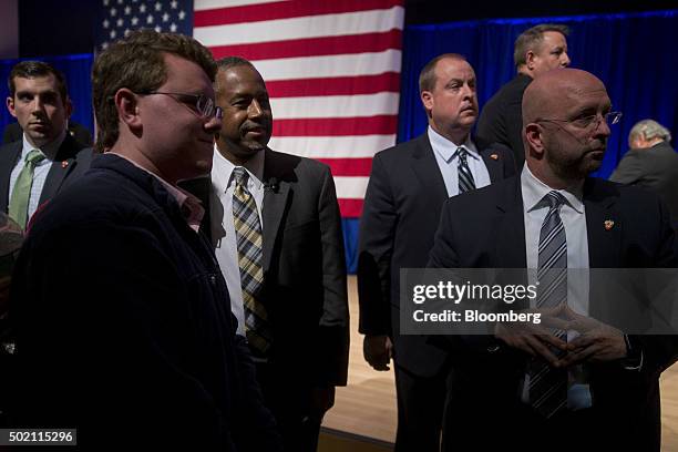 Ben Carson, retired neurosurgeon and 2016 Republican presidential candidate, third left, is surrounded by Secret Service as he takes a photograph...