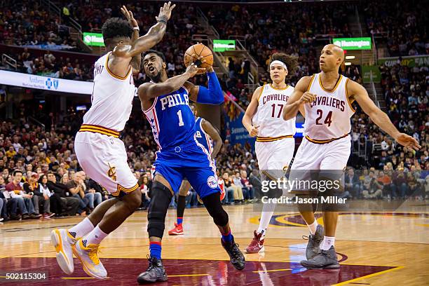 Tony Wroten of the Philadelphia 76ers tries to drive past J.R. Smith of the Cleveland Cavaliers during the first half at Quicken Loans Arena on...