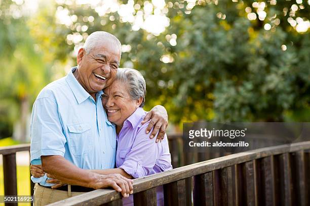 mexican coppia senior ridendo su ponte - coppia anziana foto e immagini stock