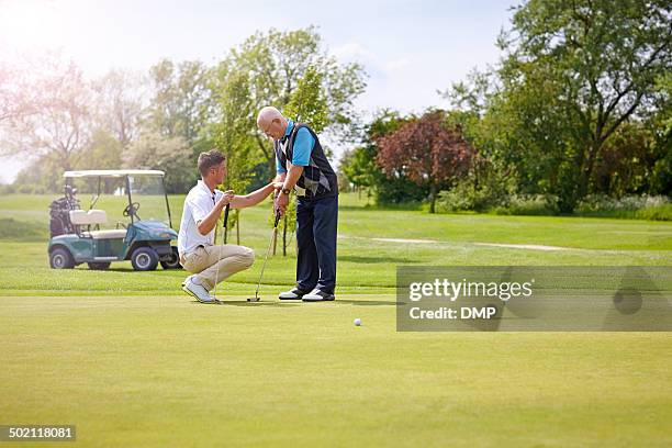 golf pro teaching a senior male - golf lessons stock pictures, royalty-free photos & images