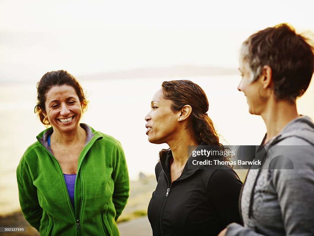 Three female friends laughing together after run
