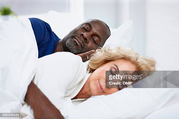 mature man sleeping on bed with woman - black man sleeping in bed stock pictures, royalty-free photos & images