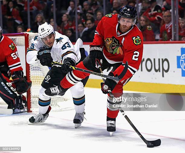 Duncan Keith of the Chicago Blackhawks clears the puck under pressure from Matt Nieto of the San Jose Sharks at the United Center on December 20,...