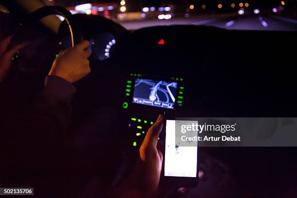 driving at night in the highway and checking the bright smartphone screen. - automotive navigation system stock pictures, royalty-free photos & images