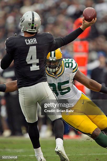 Quarterback Derek Carr of the Oakland Raiders throws under pressure from defensive end Datone Jones of the Green Bay Packers in the second quarter on...