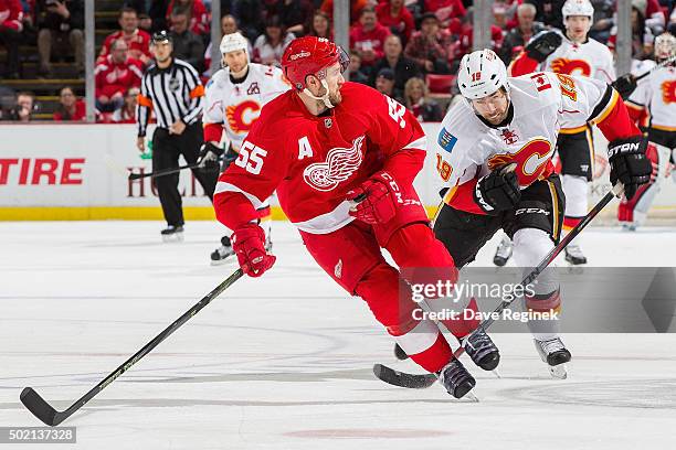 Niklas Kronwall of the Detroit Red Wings skates up ice in front of David Jones of the Calgary Flames during an NHL game at Joe Louis Arena on...