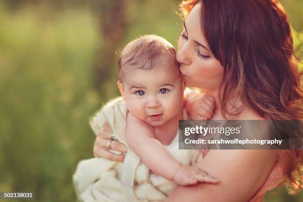 Beautiful Woman Kissing Her Babys Temple, Stockfoto
