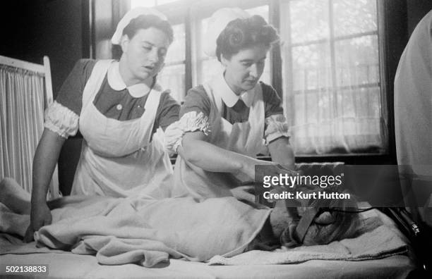 Nurses attend a patient who is receiving electro-convulsive therapy to cure depression, at a mental hospital in England, November 1946. Electrodes on...