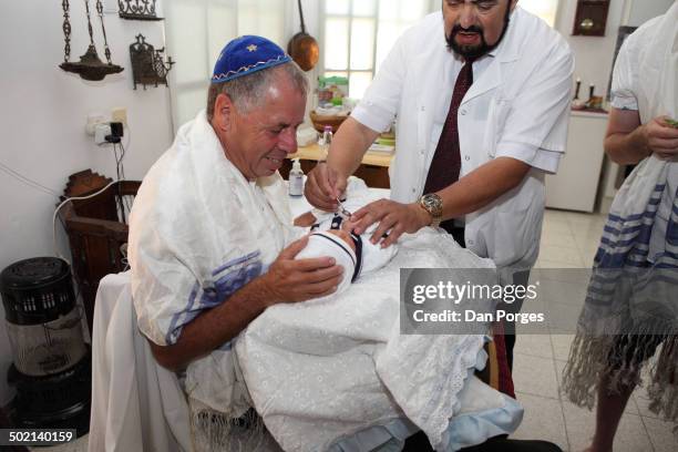 During a brit milah ceremony, a mohel offer wine to pacify an eight-day-old Jewish boy following circumcision, Had Nes, Israel, June 18, 2014. The...