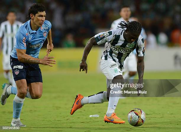 Yimmi Chara of Nacional struggles for the ball with Roberto Ovelar of Junior during a second leg final match between Atletico Nacional and Atletico...