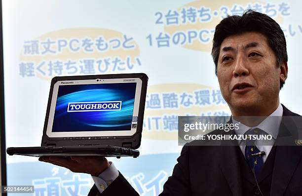 Japan's electronics giant Panasonic executive Hiroaki Sakamoto displays the new heavy duty notebook computer "Toughbook CF-20", which has a...