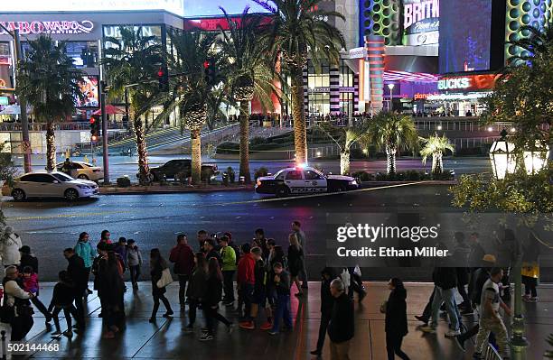 Pedestrians walk by across from Planet Hollywood Resort & Casino after police shut down all vehicle traffic on the Las Vegas Strip after a car...