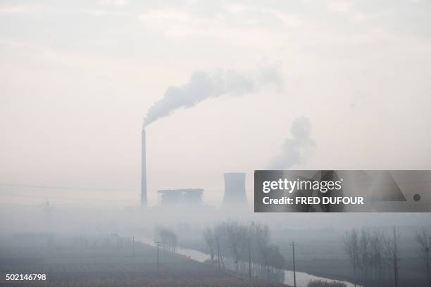 This picture taken on November 17, 2015 shows smoke bellowing from a power plant on a polluted day in Cangzhou, some 180 kms from Beijing, in...