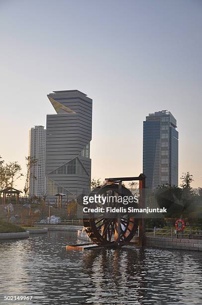 modern buildings and water wheel - water wheel stock pictures, royalty-free photos & images