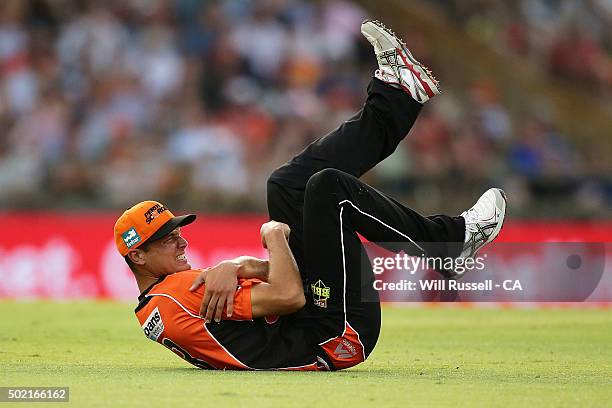 Nathan Coulter-Nile of the Scorchers grabs his shoulder after sustaining an injury during the Big Bash League match between Perth Scorchers and...