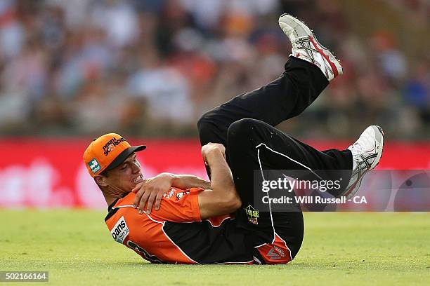 Nathan Coulter-Nile of the Scorchers grabs his shoulder after sustaining an injury during the Big Bash League match between Perth Scorchers and...