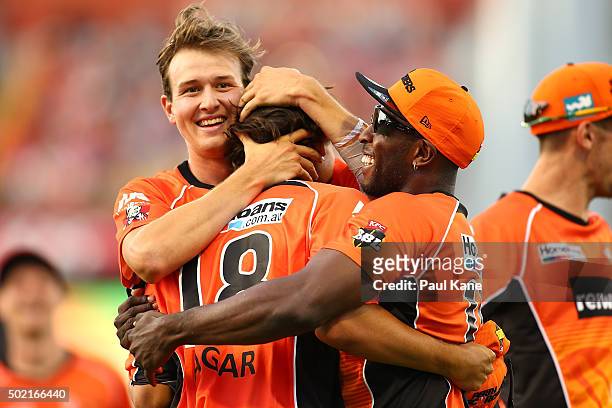 Joel Paris and Michael Carberry of the Scorchers congratulate Ashton Agar after taking a catch to dismiss Brad Hodge of the Strikers during the Big...