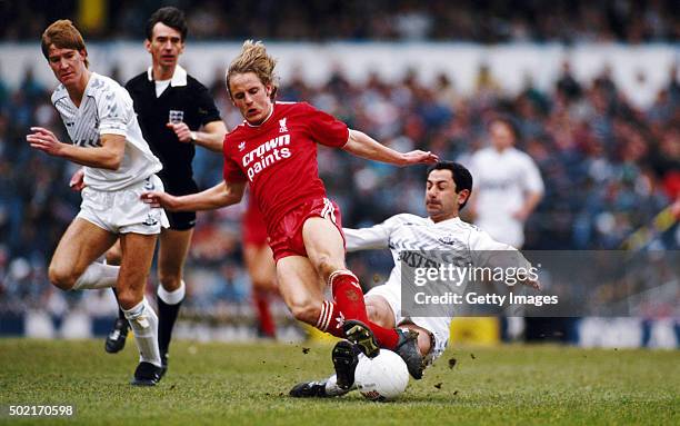 Liverpool striker Paul Walsh is tackled from behind by Spurs player Ossie Ardiles as defender Richard Gough looks on during the First Divison match...