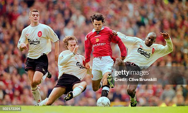 Manchester United winger Ryan Giggs is challenged by Jason McAteer and Michael Thomas as Dominic Matteo looks on during the FA Premier League match...