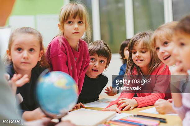 preschool teacher and children learning in classroom. - boy asking stock pictures, royalty-free photos & images