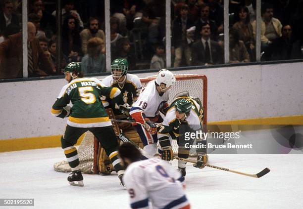 Neal Broten of the Minnesota North Stars is checked by Bryan Trottier of the New York Islanders during the 1981 Stanley Cup Finals in May, 1981 at...