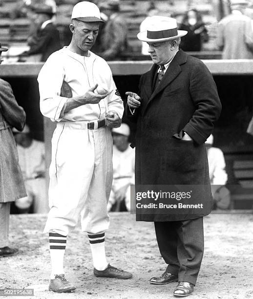 Pitcher Grover Cleveland Alexander of the St. Louis Cardinals shows manager John McGraw of the New York Giants a baseball before a game circa 1926 at...