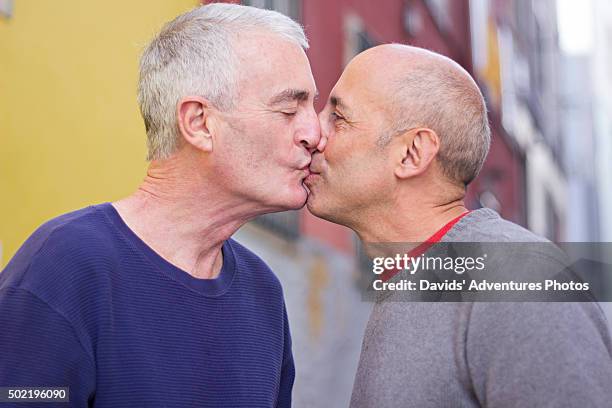 senior mature gay couple on vacation and kissing - only mature men stock pictures, royalty-free photos & images