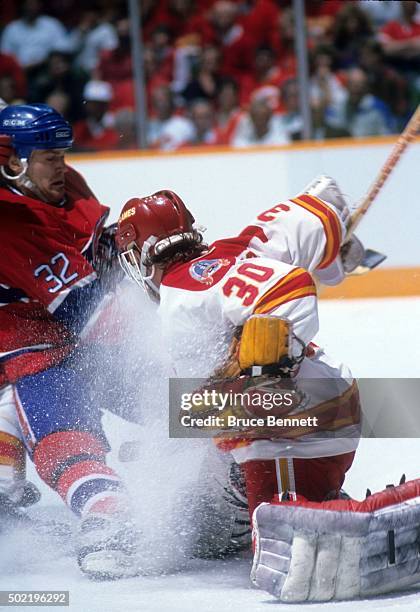 Claude Lemieux of the Montreal Canadiens collides with goalie Mike Vernon of the Calgary Flames during the 1989 Stanley Cup Finals in May, 1989 at...