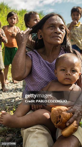 Waorani indigenous woman holds a baby in Gareno, 175 km southeast of Quito, Ecuador on December 7, 2015. Three Amazonian ethnic groups of Ecuador,...