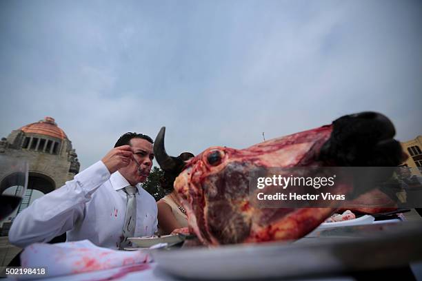 An activist from Animal Heroes NGO performs to denounce the excessive consumption of meat during the Christmas season at Monumento a la Revolución on...