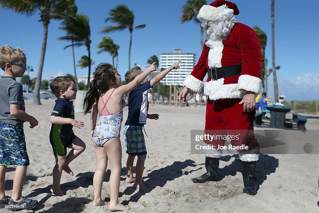 Santa Passes Out Presents On The Beach In Fort Lauderdale, Florida