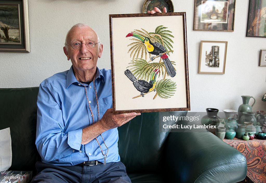Senior man proudly showing his embroidered artwork