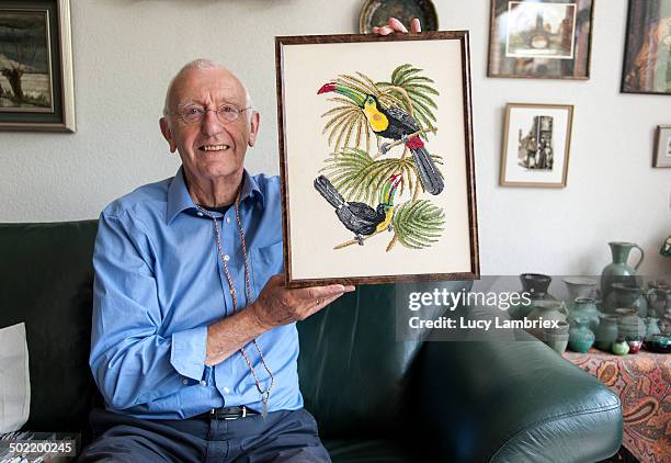 senior man proudly showing his embroidered artwork - holding stock pictures, royalty-free photos & images