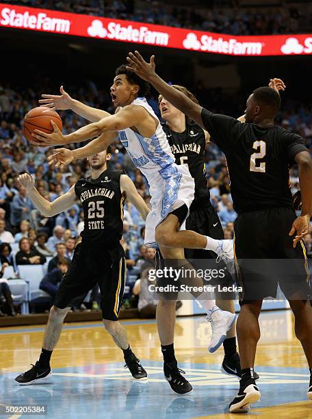 Marcus Paige of the North Carolina Tar Heels drives past teammates Griffin Kinney and Ronshad Shabazz of the Appalachian State Mountaineers during...