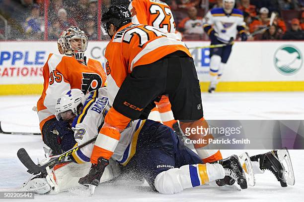 David Backes of the St. Louis Blues collides with goalie Steve Mason of the Philadelphia Flyers in the first period at Wells Fargo Center on December...