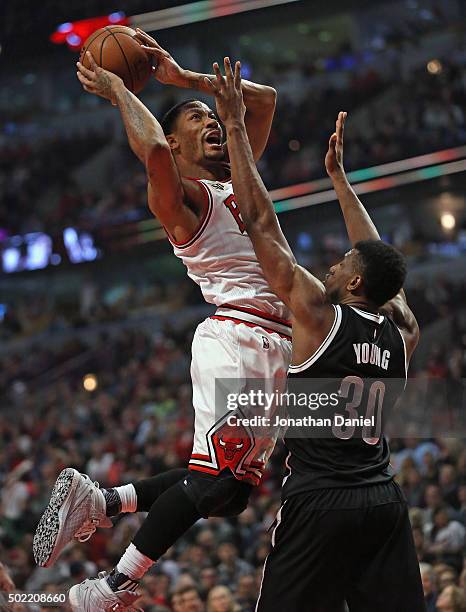 Derrick Rose of the Chicago Bulls shoots over Thaddeus Young of the Brooklyn Nets at the United Center on December 21, 2015 in Chicago, Illinois. The...