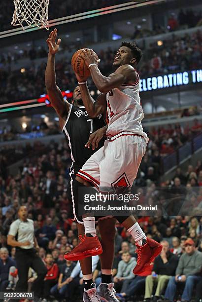 Jimmy Butler of the Chicago Bulls puts up a shot against Joe Johnson of the Brooklyn Netson his way to a game-high 24 points at the United Center on...