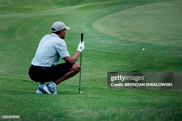 President Barack Obama lines up a chip on the 18th green of the Mid-Pacific Country Club's golf course December 21, 2015 in Kailua, Hawaii. Obama and...