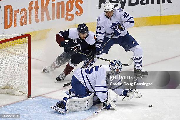 Goalie Jonathan Bernier of the Toronto Maple Leafs collects the puck as Roman Polak of the Toronto Maple Leafs defends against John Mitchell of the...