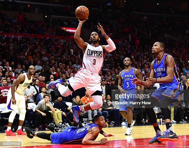 Chris Paul of the Los Angeles Clippers scores off of an inbound steal to Russell Westbrook of the Oklahoma City Thunder as Kevin Durant and Dion...