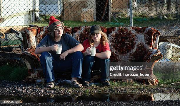 boys drinking milk on a discarded couch - poverty in america - fotografias e filmes do acervo