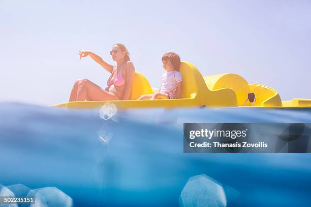 mother with her son riding on paddle boat - pedal boat photos et images de collection